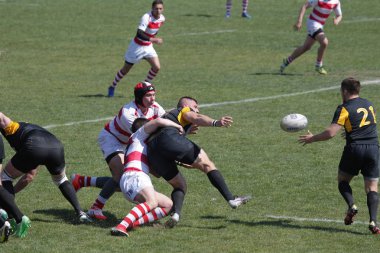 Odessa, Ukrayna - 6 Nisan 2019: Milli takım amentü (Odessa)-Olimpiyat (Kharkov) Rugby Şampiyonası. Gergin mücadele oyuncu topu için rugby testi sırasında. Stadyum yeşil alan üzerinde dinamik oyun