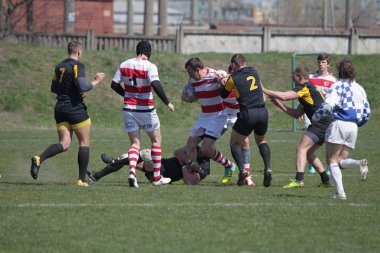 Odessa, Ukrayna - 6 Nisan 2019: Milli takım amentü (Odessa)-Olimpiyat (Kharkov) Rugby Şampiyonası. Gergin mücadele oyuncu topu için rugby testi sırasında. Stadyum yeşil alan üzerinde dinamik oyun