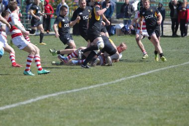 Odessa, Ukrayna - 6 Nisan 2019: Milli takım amentü (Odessa)-Olimpiyat (Kharkov) Rugby Şampiyonası. Gergin mücadele oyuncu topu için rugby testi sırasında. Stadyum yeşil alan üzerinde dinamik oyun