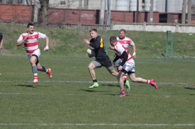 Odessa, Ukrayna - 6 Nisan 2019: Milli takım amentü (Odessa)-Olimpiyat (Kharkov) Rugby Şampiyonası. Gergin mücadele oyuncu topu için rugby testi sırasında. Stadyum yeşil alan üzerinde dinamik oyun