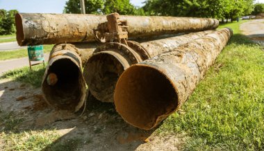 Eski büyük su boruları parçaları. Sonra uzun yıllar çalışma aşınmış metal boru yok. Paslı çelik boru delik metal korozyon ile. Seçici odak.