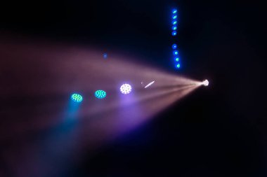 Sahne ışıkları. Karanlıkta birkaç projektör var. Gösteri sırasında sahnenin sahne ışıklarından gelen çok renkli ışık demetleri sahnenin dumanının içinde. Gece kulübü. Işıklar açık. Lazer gösterisi