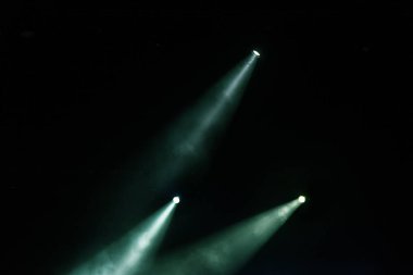 Sahne ışıkları. Karanlıkta birkaç projektör var. Gösteri sırasında sahnenin sahne ışıklarından gelen çok renkli ışık demetleri sahnenin dumanının içinde. Gece kulübü. Işıklar açık. Lazer gösterisi