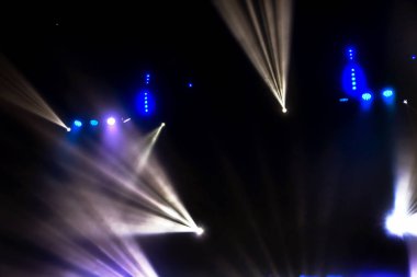 Sahne ışıkları. Karanlıkta birkaç projektör var. Gösteri sırasında sahnenin sahne ışıklarından gelen çok renkli ışık demetleri sahnenin dumanının içinde. Gece kulübü. Işıklar açık. Lazer gösterisi
