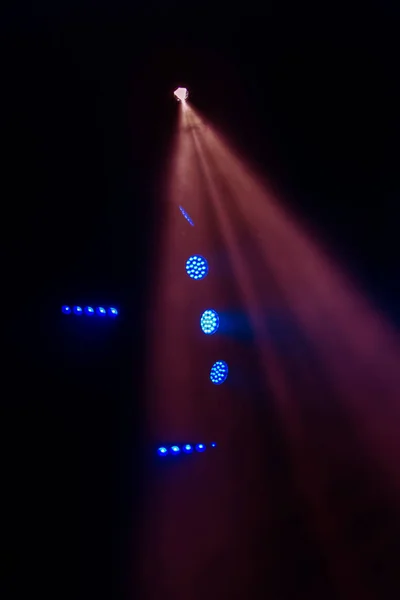 舞台灯光 几个投影仪在黑暗中 在娱乐节目期间 舞台上的彩灯在烟雾弥漫的舞台上发出了多彩的光芒 夜总会 Lazer秀 — 图库照片
