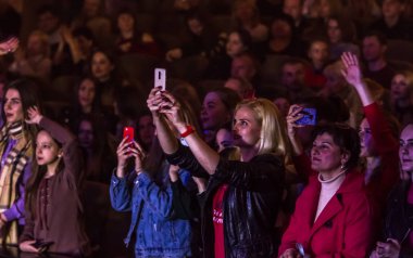 Odessa, Ukrayna-12 Nisan 2019: rock konseri Alekseev 'de seyirci kitleleri müzik gösterisi sırasında. Mutlu insanlar kalabalık rock konseri zevk, ellerini yükseltmek ve ellerini alkış, podiu üzerinde seyirci