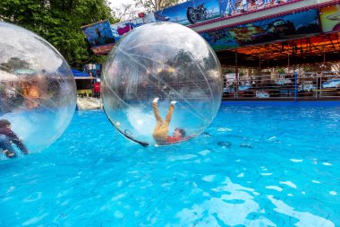 Odessa, Ukrayna - 6 Mayıs 2019. Şişme balondaki küçük çocuklar, suda eğleniyorlar. Suda top - çocuklar için büyüleyici yaz konumlar. Su zorlama