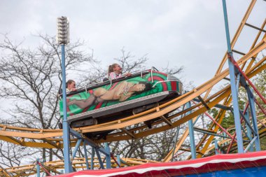 Odessa, Ukrayna - 6 Mayıs 2019: Ziyaretçiler bir lunaparkta yol kaydıraklarına biniyor. Heyecan verici bir lunapark treninde genç arkadaşlar. Gençler lunaparkta eğleniyor. Lunapark treninde korkunç eğlence