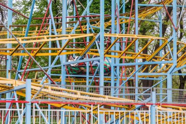 Odessa, Ukrayna - 6 Mayıs 2019: Ziyaretçiler bir lunaparkta yol kaydıraklarına biniyor. Heyecan verici bir lunapark treninde genç arkadaşlar. Gençler lunaparkta eğleniyor. Lunapark treninde korkunç eğlence