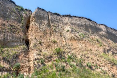 Karadeniz kıyısındaki heyelan bölgesi. Deniz taşı kabuğu. Yağmur mevsiminde doğal afetler bölgesi. Büyük toprak kütleleri tepenin yamacında kayıp evleri yok ediyor. Heyelan - yaşam tehdidi