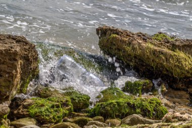 Kavramsal: felaket, çevresel sorun-plastik çöp. Büyük şehrin plajına çöp dökülmüş. Boş kullanılmış kirli plastik şişeler. Karanlık deniz, Karadeniz 'in kumlu kıyısı. Çevre kirliliği