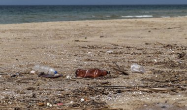 Kavramsal: felaket, çevresel sorun-plastik çöp. Büyük şehrin plajına çöp dökülmüş. Boş kullanılmış kirli plastik şişeler. Karanlık deniz, Karadeniz 'in kumlu kıyısı. Çevre kirliliği