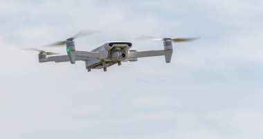 Profesyonel filme drone mavi bir gökyüzüne karşı düşük irtifada havada uçar. Drone fotoğraf yapar. Modern yeni teknoloji. Metin için yer ile hazır arka plan