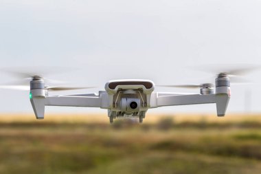 Profesyonel filme drone mavi bir gökyüzüne karşı düşük irtifada havada uçar. Drone fotoğraf yapar. Modern yeni teknoloji. Metin için yer ile hazır arka plan