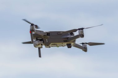 Profesyonel filme drone mavi bir gökyüzüne karşı düşük irtifada havada uçar. Drone fotoğraf yapar. Modern yeni teknoloji. Metin için yer ile hazır arka plan