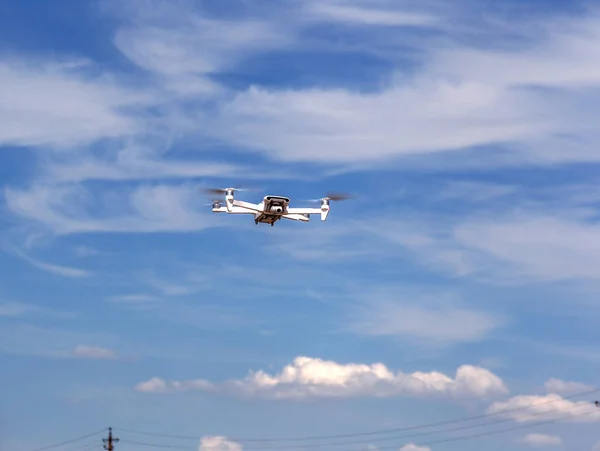 Professional filming drone flies in the air at a low altitude against a blue sky. Drone makes photos. Modern new technology. Ready background with place for your text