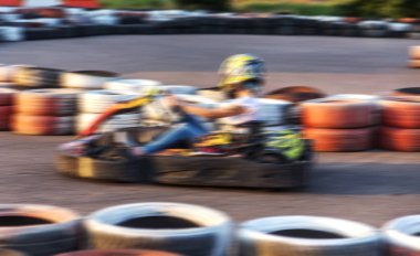 Güçlü hareket bulanıklığı karting. Resim odak dışında. Araba lastikleri ile sınırlı özel güvenli yüksek hızlı parça üzerinde yarışlarda Yarışçılar. At arabalarında Attraction Yüksek hızlı sürüş. Spor karting eğlence