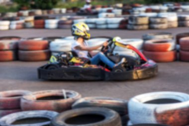 Güçlü hareket bulanıklığı karting. Resim odak dışında. Araba lastikleri ile sınırlı özel güvenli yüksek hızlı parça üzerinde yarışlarda Yarışçılar. At arabalarında Attraction Yüksek hızlı sürüş. Spor karting eğlence