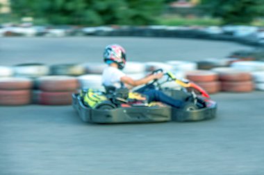 Güçlü hareket bulanıklığı karting. Resim odak dışında. Araba lastikleri ile sınırlı özel güvenli yüksek hızlı parça üzerinde yarışlarda Yarışçılar. At arabalarında Attraction Yüksek hızlı sürüş. Spor karting eğlence