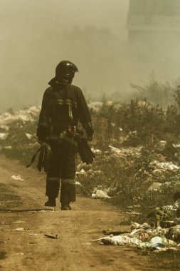 Bozkırda ateş. Orman ve bozkır yangınları şiddetli kuraklık lar sırasında tarlaları ve bozkırları tamamen yok eder. Felaket, doğaya zarar, yangın evleri riski. İtfaiyeci yangın yeri teftiş ile etrafında yürüyor