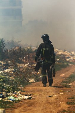 Bozkırda ateş. Orman ve bozkır yangınları şiddetli kuraklık lar sırasında tarlaları ve bozkırları tamamen yok eder. Felaket, doğaya zarar, yangın evleri riski. İtfaiyeci yangın yeri teftiş ile etrafında yürüyor