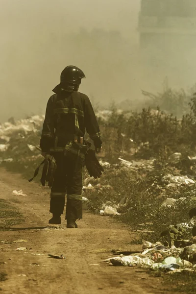 Fire in steppe. Forest and steppe fire completely destroy fields and steppes during severe droughts. Disaster, damage to nature, risk of fire houses. Fireman walks around with inspection of fire place