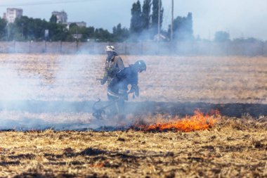 Odessa, Ukrayna - Cirka 2019: Bozkır Yangınları. Tahıl koşum saman ve saman hasat sonra sahada. Felaket. Ateş ve duman tüm yaşamı yok eder. İtfaiyeciler Büyük Yangını söndürür. Çok duman