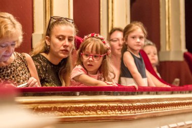 Odessa, Ukrayna - Circa 2019: seçici odak. Popüler çocuk oyunu sırasında tiyatroseyirci çocuklar. Çocuk Lokumu seyircisi. Konser seyircisi hareket halinde. Tiyatroda çocuk seyircisi