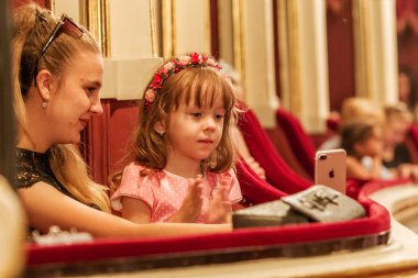 Odessa, Ukrayna - Circa 2019: seçici odak. Popüler çocuk oyunu sırasında tiyatroseyirci çocuklar. Çocuk Lokumu seyircisi. Konser seyircisi hareket halinde. Tiyatroda çocuk seyircisi