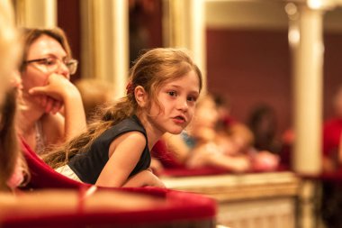 Odessa, Ukrayna - Circa 2019: seçici odak. Popüler çocuk oyunu sırasında tiyatroseyirci çocuklar. Çocuk Lokumu seyircisi. Konser seyircisi hareket halinde. Tiyatroda çocuk seyircisi