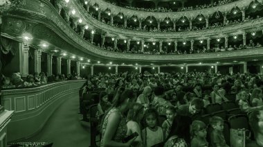 Odessa, Ukrayna - Circa 2019: seçici odak. Popüler çocuk oyunu sırasında tiyatroseyirci çocuklar. Çocuk Lokumu seyircisi. Konser seyircisi hareket halinde. Tiyatroda çocuk seyircisi