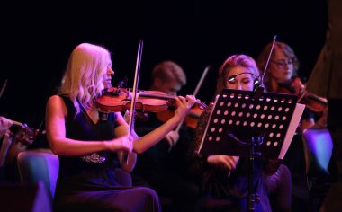Odessa, Ukrayna - 16 Temmuz 2019: Andrey Cherny senfoni orkestrası tarafından Odessa Opera Tiyatrosu'nun tiyatro sahnesinde konser. Senfoni orkestrası müzisyenlerOscar sinematik hit gerçekleştirmek