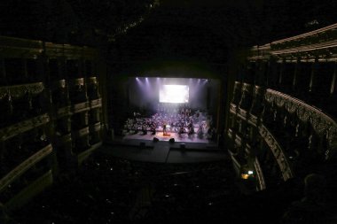 Odessa, Ukrayna - 16 Temmuz 2019: Andrey Cherny senfoni orkestrası tarafından Odessa Opera Tiyatrosu'nun tiyatro sahnesinde konser. Senfoni orkestrası müzisyenlerOscar sinematik hit gerçekleştirmek