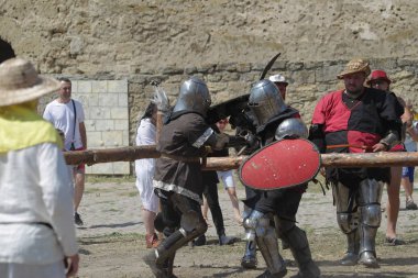 Odessa, Ukrayna - 20 Temmuz 2019: Ortaçağ performansında ortaçağ silahlarıyla Şövalyelerin Savaşı. Şövalyeler ortaçağ kültür festivali savaş turnuvası sırasında sahada mücadele