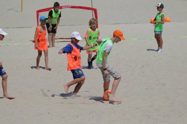 Odessa Ukrayna-Temmuz 28, 2019: yerel turnuvada futbol oynayan çocuklar tatil Karadeniz plajında organize. Arka planda deniz ile sahilde futbol topu ile oynayan çocuk grubu