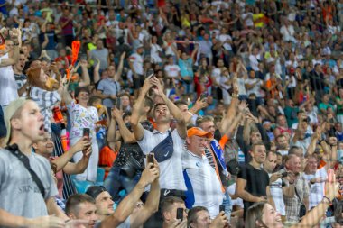 ODESSA UKRAINE - July 28, 2019: spectators at stadium. Crowds of fans in stands of football stadium during match Shakhtar (Donetsk) -Dynamo (Kiev). Grandstand with fans. Stands with football fans clipart