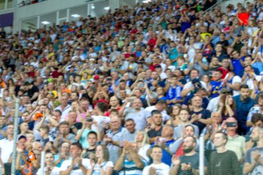 Odessa Ukrayna - 28 Temmuz 2019: Odak dışında değil, keskin spor arka plan - stadyumda seyirci. Maç sırasında futbol stadyumu tribünlerinde taraftarlar tribünlerde taraftarlar la Tribune. Futbol taraftarları ile standları