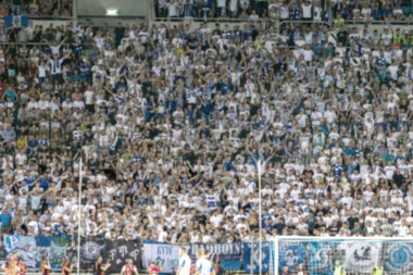 Odessa Ukrayna - 28 Temmuz 2019: Odak dışında değil, keskin spor arka plan - stadyumda seyirci. Maç sırasında futbol stadyumu tribünlerinde taraftarlar tribünlerde taraftarlar la Tribune. Futbol taraftarları ile standları