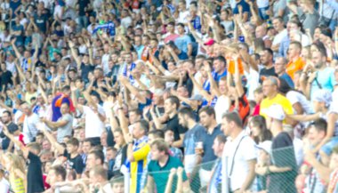 Odessa Ukrayna - 28 Temmuz 2019: Odak dışında değil, keskin spor arka plan - stadyumda seyirci. Maç sırasında futbol stadyumu tribünlerinde taraftarlar tribünlerde taraftarlar la Tribune. Futbol taraftarları ile standları