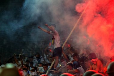 Odessa, Ukrayna -Temmuz28,2019: Fanatik taraftarlar ebedi rakipleri oyun sırasında standında. Raflarda hayranları mutlu, ateş ve bayrak sallayarak parlıyor. Stadyumda ateşli bir gösteri. Holigan ışık ateşli flaş Fan