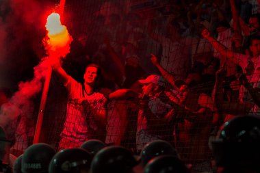 Odessa, Ukrayna -Temmuz28,2019: Fanatik taraftarlar ebedi rakipleri oyun sırasında standında. Raflarda hayranları mutlu, ateş ve bayrak sallayarak parlıyor. Stadyumda ateşli bir gösteri. Holigan ışık ateşli flaş Fan