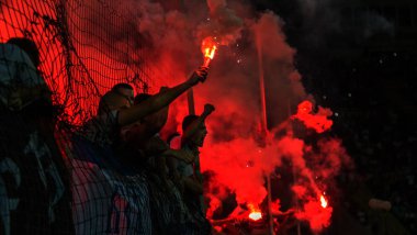 Odessa, Ukrayna -Temmuz28,2019: Fanatik taraftarlar ebedi rakipleri oyun sırasında standında. Raflarda hayranları mutlu, ateş ve bayrak sallayarak parlıyor. Stadyumda ateşli bir gösteri. Holigan ışık ateşli flaş Fan