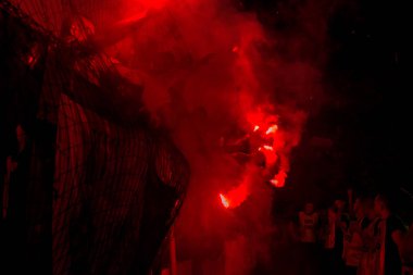 Odessa, Ukrayna -Temmuz28,2019: Fanatik taraftarlar ebedi rakipleri oyun sırasında standında. Raflarda hayranları mutlu, ateş ve bayrak sallayarak parlıyor. Stadyumda ateşli bir gösteri. Holigan ışık ateşli flaş Fan