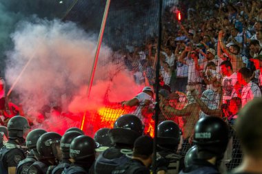 Odessa, Ukrayna -Temmuz28,2019: Fanatik taraftarlar ebedi rakipleri oyun sırasında standında. Raflarda hayranları mutlu, ateş ve bayrak sallayarak parlıyor. Stadyumda ateşli bir gösteri. Holigan ışık ateşli flaş Fan