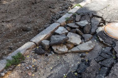 Büyük çatlaklar, cipsler. Kırık asfalt sel sonrası heyelan değiştirdi. Su yla yok edilmiş bir yol. Yeraltı suyu sifonu. Doğadan yolların tahrip kavramı. Selin sonuçları. Kırık sokak