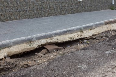 Büyük çatlaklar, cipsler. Kırık asfalt sel sonrası heyelan değiştirdi. Su yla yok edilmiş bir yol. Yeraltı suyu sifonu. Doğadan yolların tahrip kavramı. Selin sonuçları. Kırık sokak