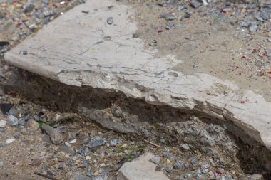 Büyük çatlaklar, cipsler. Kırık asfalt sel sonrası heyelan değiştirdi. Su yla yok edilmiş bir yol. Yeraltı suyu sifonu. Doğadan yolların tahrip kavramı. Selin sonuçları. Kırık sokak