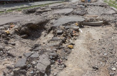 Büyük çatlaklar, cipsler. Kırık asfalt sel sonrası heyelan değiştirdi. Su yla yok edilmiş bir yol. Yeraltı suyu sifonu. Doğadan yolların tahrip kavramı. Selin sonuçları. Kırık sokak