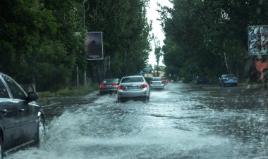 Odessa, Ukrayna -9 Ağustos 2019: sağanak yağışların neden olduğu sel felaketi sırasında su lar altında kalan yolda araba sürmek. Arabalar su üzerinde yüzüyor, sokakları su basayor. Arabaya sıçrat. Büyük bir su birikintisi ile sular altında şehir yolu