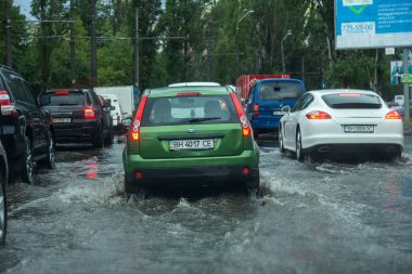Odessa, Ukrayna -9 Ağustos 2019: sağanak yağışların neden olduğu sel felaketi sırasında su lar altında kalan yolda araba sürmek. Arabalar su üzerinde yüzüyor, sokakları su basayor. Arabaya sıçrat. Büyük bir su birikintisi ile sular altında şehir yolu